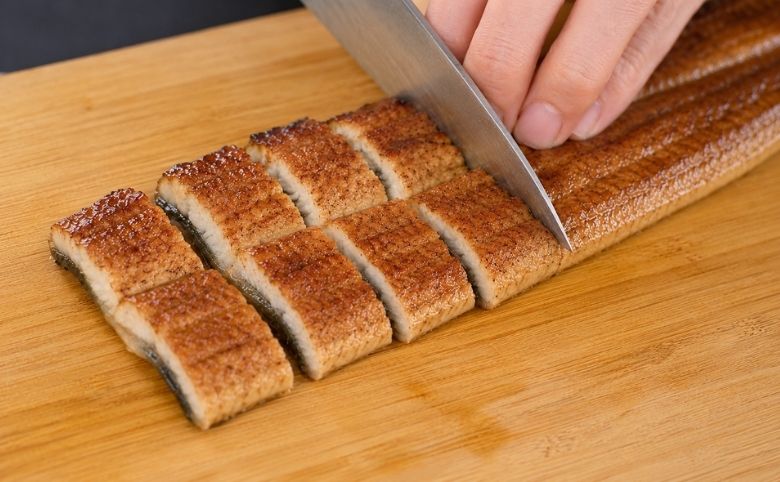 余分なタレを落としたうなぎをカットする
